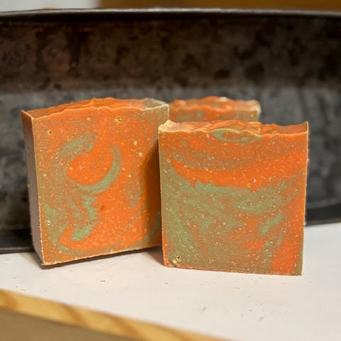 Sweet Orange & Clove Essential Oil scented oat milk soap in orange and pale green swirls