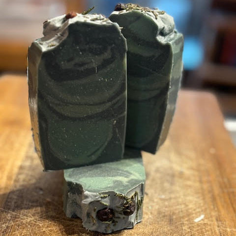 balsam Fir scented -5 oz  goat milk soap with three tones of green swirl topped with juniper berries and balsam fir sprigs