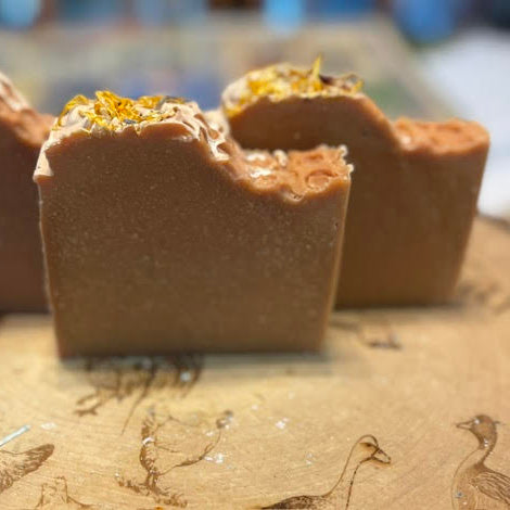 Brown Soap with Oatmeal Milk, Honey Fragrance Oil and Peppermint Essential Oil, the top has a honeycomb pattern and calendula petals as decoration