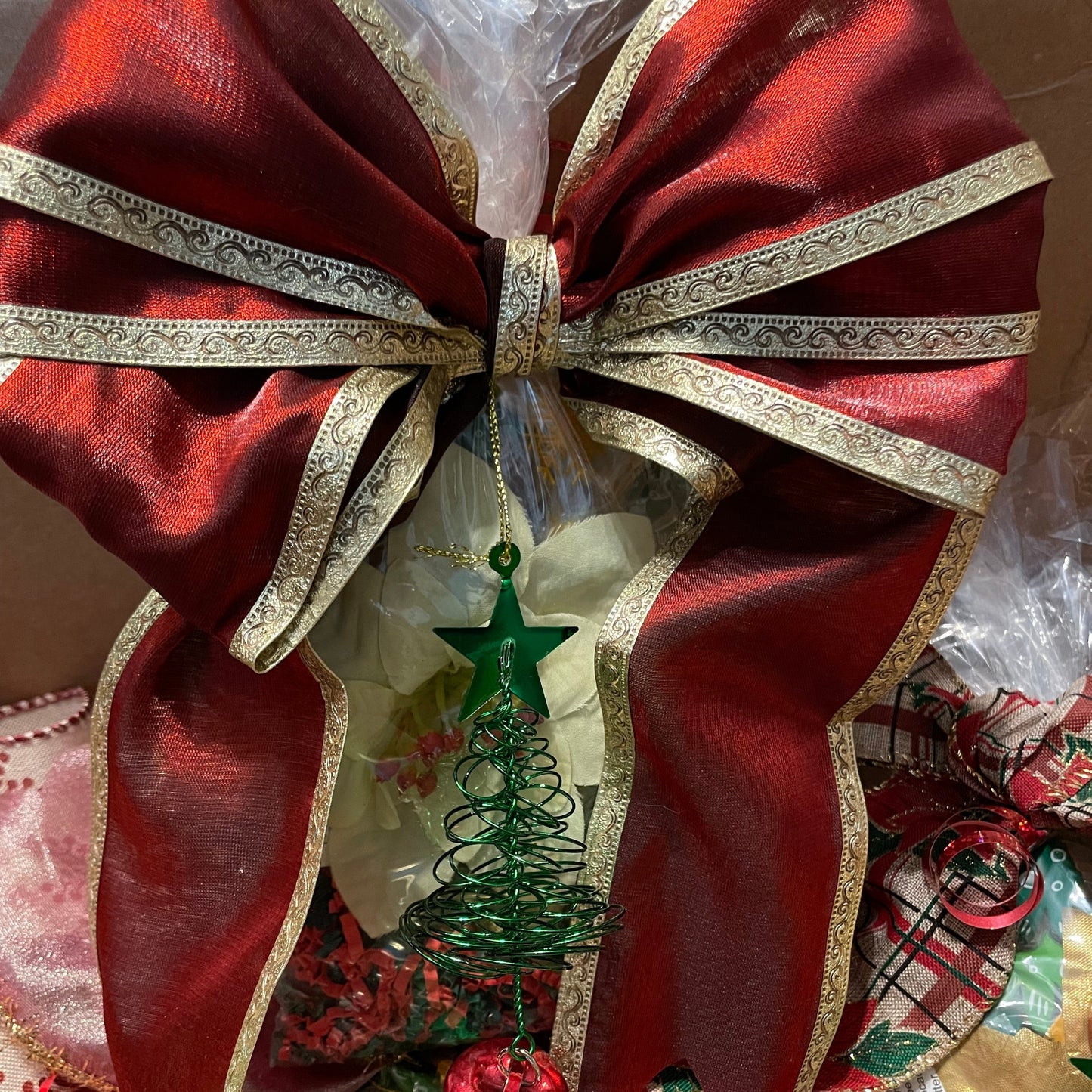 close up picture of gift set with large red ribbon and a small ornament