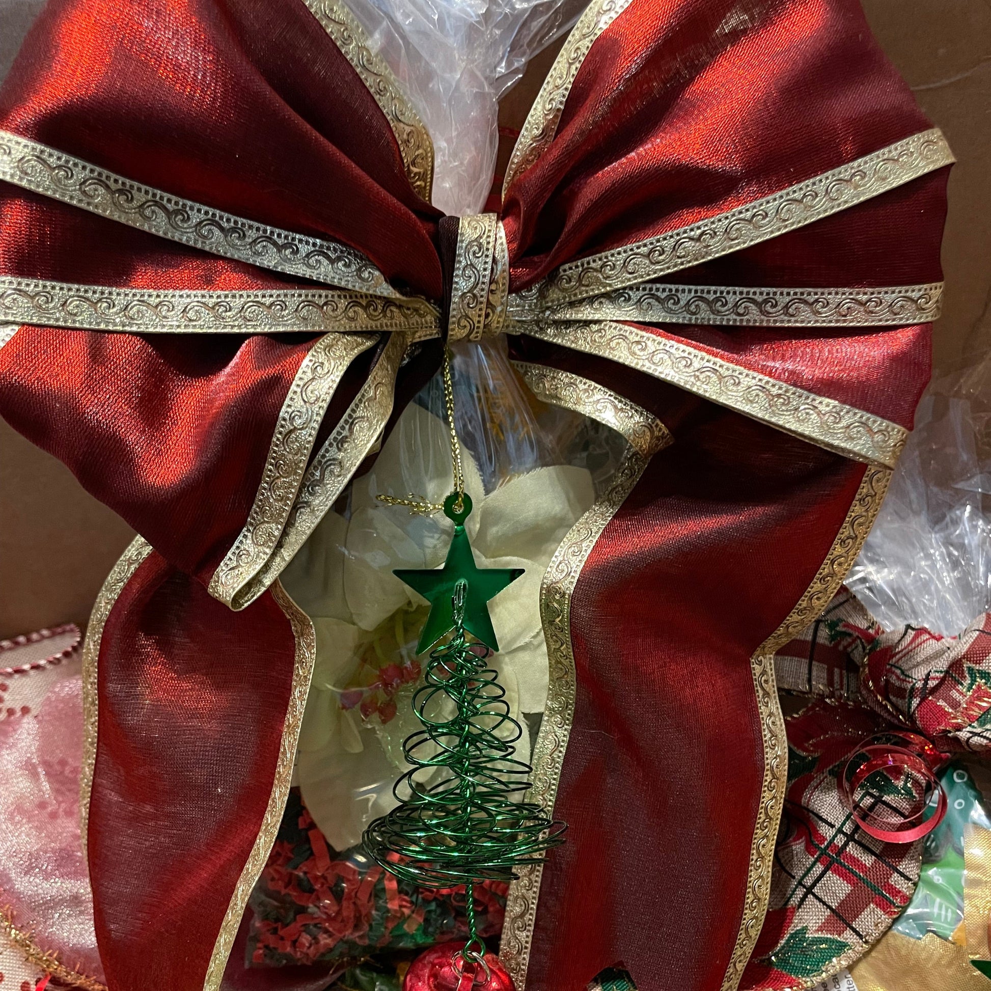 close up picture of gift set with large red ribbon and a small ornament