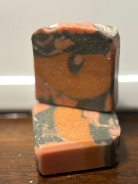 sleigh ride scent goat milk soap with black, yellow and red swirl