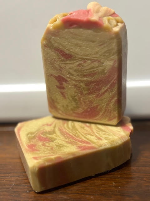 spruce swirl goat milk soap with a red, green and off-white swirl