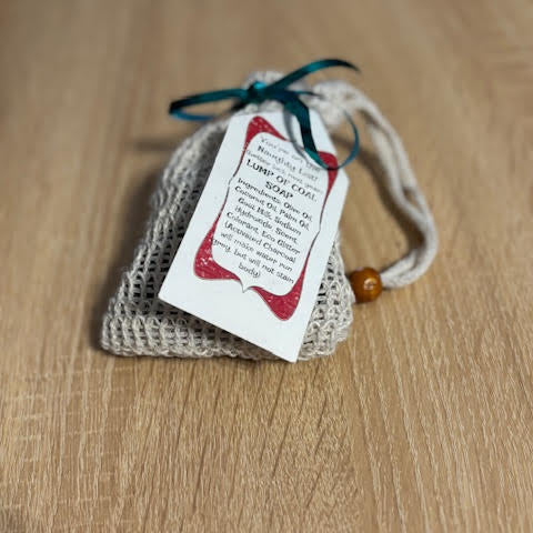 Goat milk soap formed as lumps of coal, packaged in a sisal soap saver bag